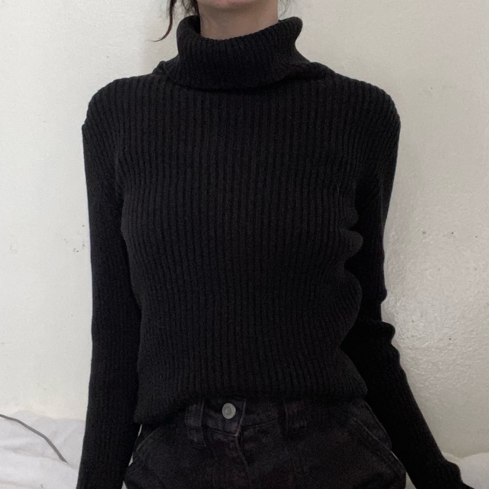 Black knitted turtle neck sweater with ribbed vertical texture